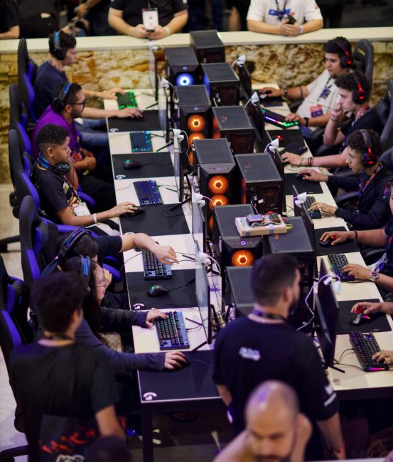 Players engaged in an intense e-sports competition, focused on screens.